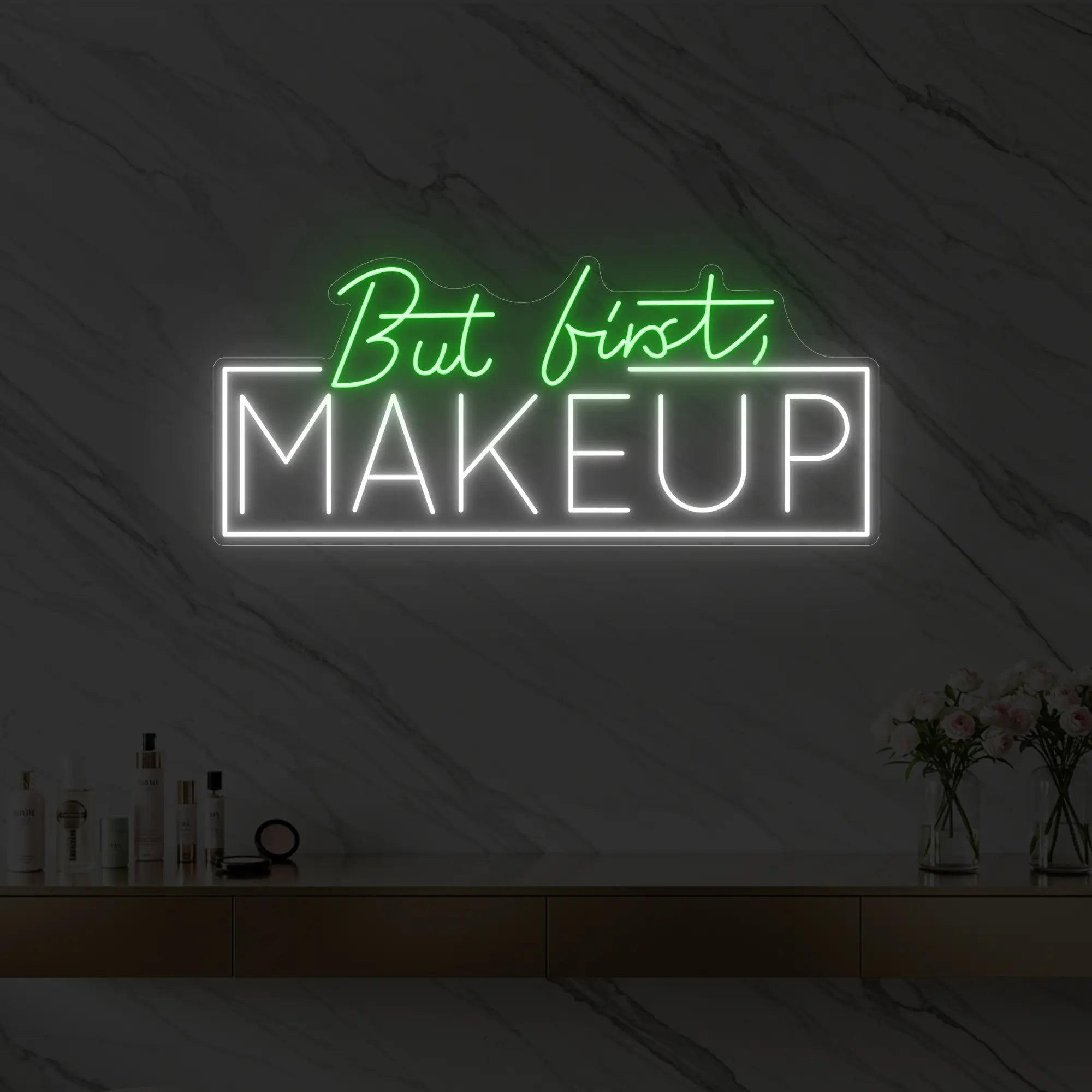 Photo of the 'But first, MAKEUP' neon sign glowing in green against a styled interior wall.