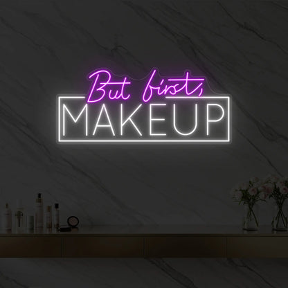 Photo of the 'But first, MAKEUP' neon sign glowing in deep pink against a styled interior wall.