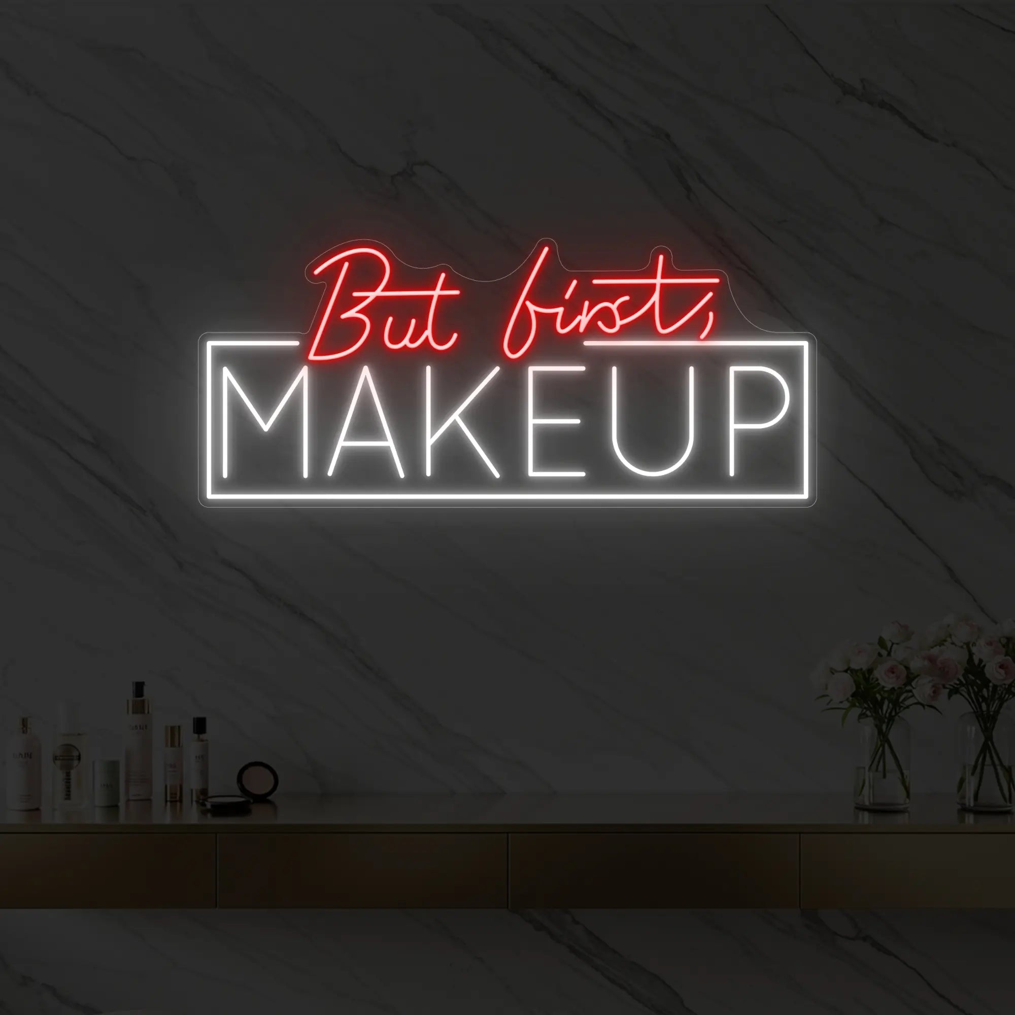 Photo of the 'But first, MAKEUP' neon sign glowing in red against a styled interior wall.