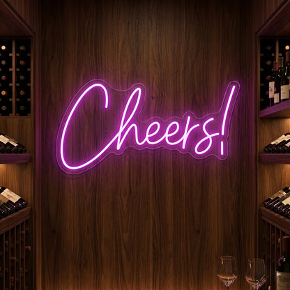 Photo of the 'CHEERS!' neon sign glowing in deep pink against a styled interior wall.