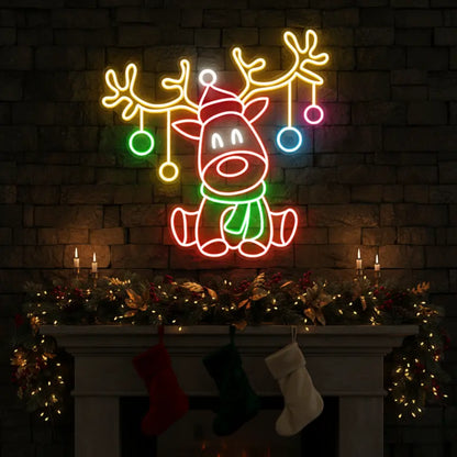 Photo of the 'Christmas Reindeer' neon sign glowing in multicolor against a styled interior wall.