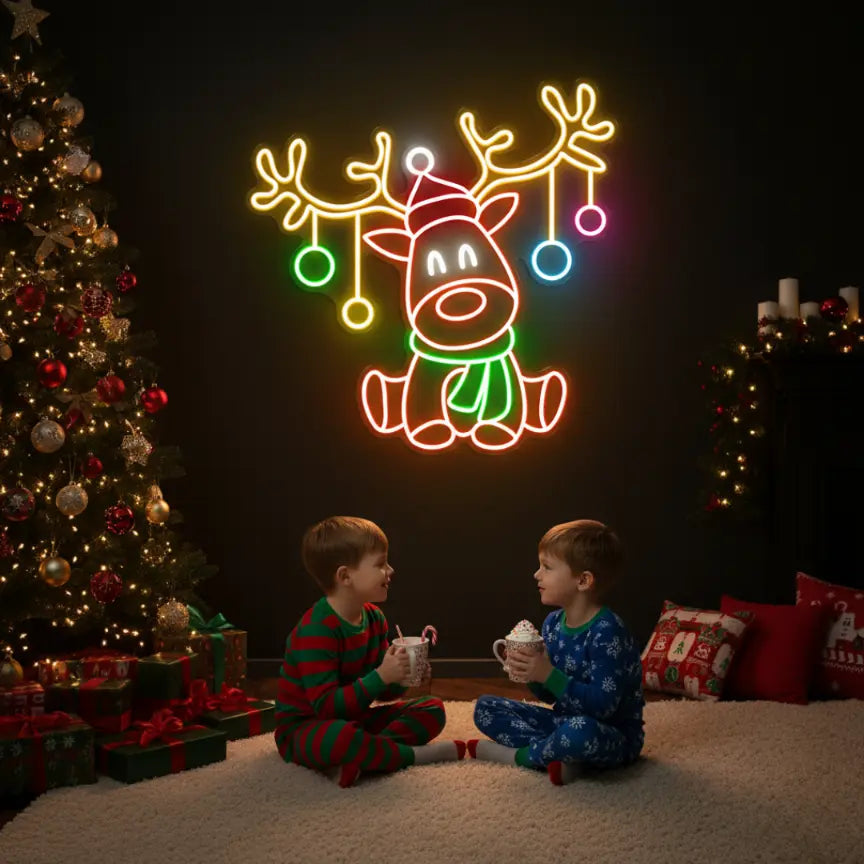 Photo of the 'Christmas Reindeer' neon sign glowing in multicolor against a styled interior wall.