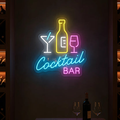 Photo of the 'COCKTAIL BAR' neon sign glowing in multi-color against a styled interior wall.