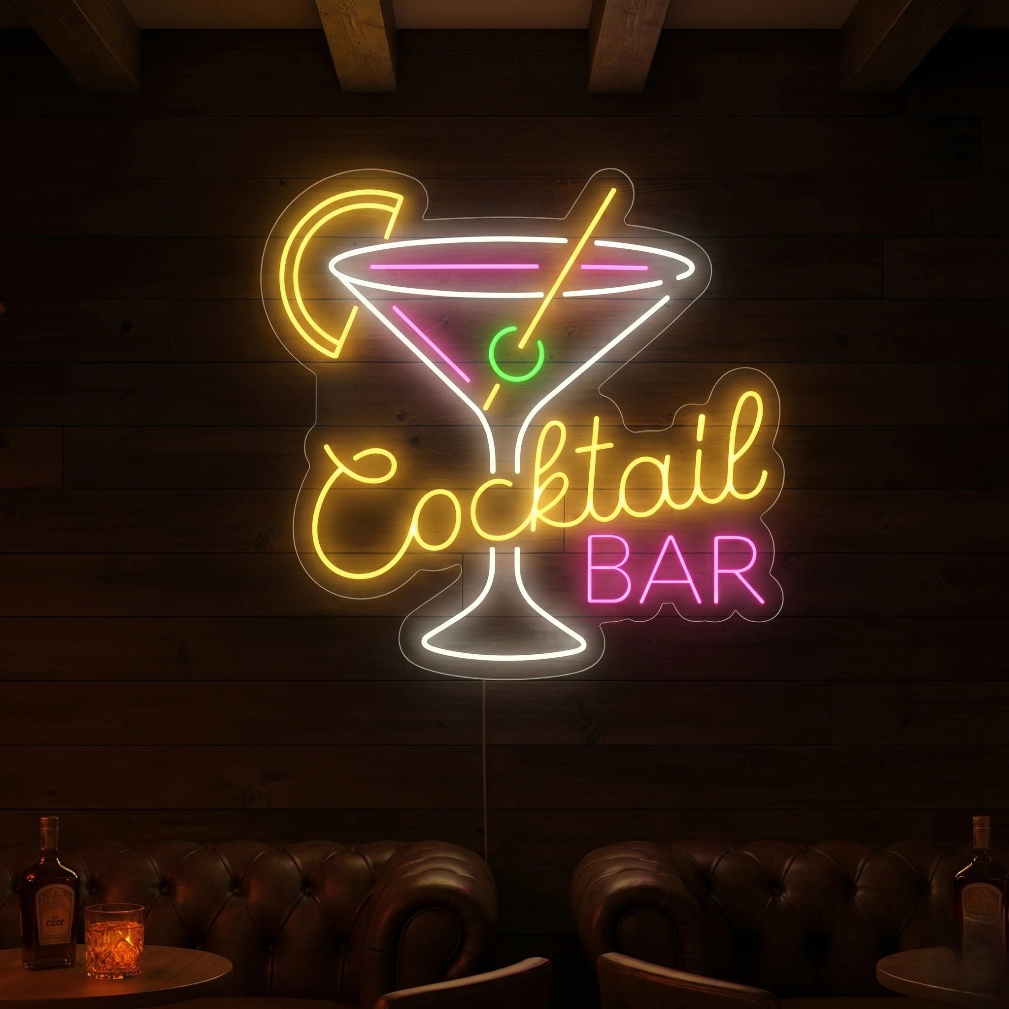 Photo of the 'COCKTAIL BAR' neon sign glowing in multi-color against a styled interior wall.