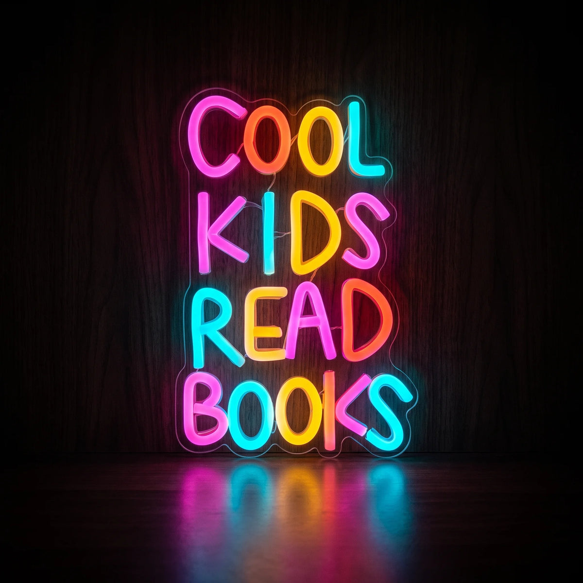 COOL KIDS READ BOOKS LED neon sign with colorful pink, blue, yellow, and red-orange lettering on acrylic backing.
