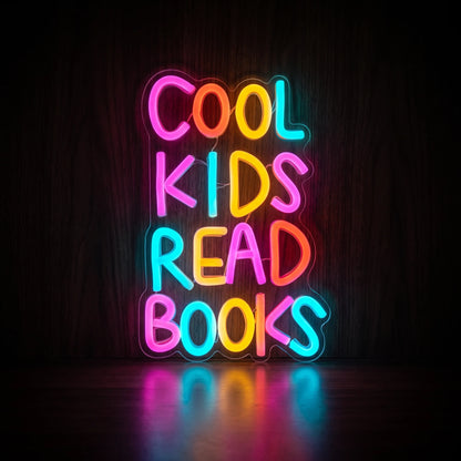 COOL KIDS READ BOOKS LED neon sign with colorful pink, blue, yellow, and red-orange lettering on acrylic backing.
