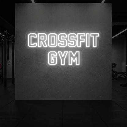  'CrossFit Gym' neon sign glowing in cool white against a styled interior wall.