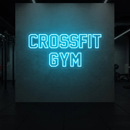  'CrossFit Gym' neon sign glowing in ice blue against a styled interior wall.