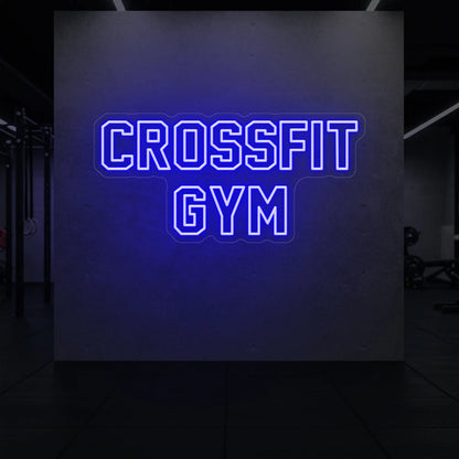  'CrossFit Gym' neon sign glowing in deep blue against a styled interior wall.