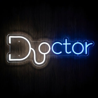 Doctor Stethoscope Typography LED Neon Sign featuring the word Doctor in blue and white glowing letters with a white stethoscope integrated into the design, mounted on clear acrylic against a dark wooden wall.