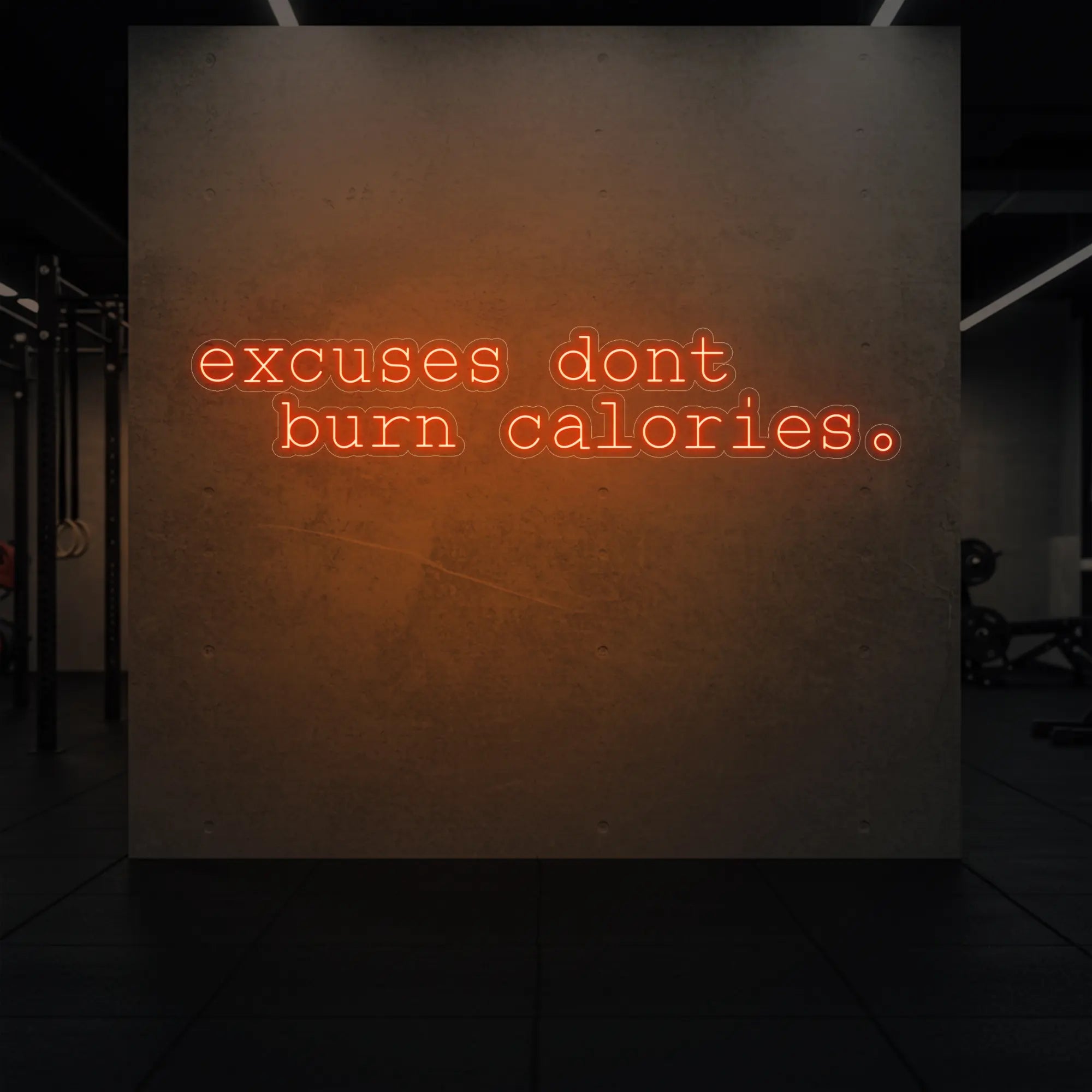  'Excuses Don’t Burn Calories' neon sign glowing in golden yellow against a styled interior wall.