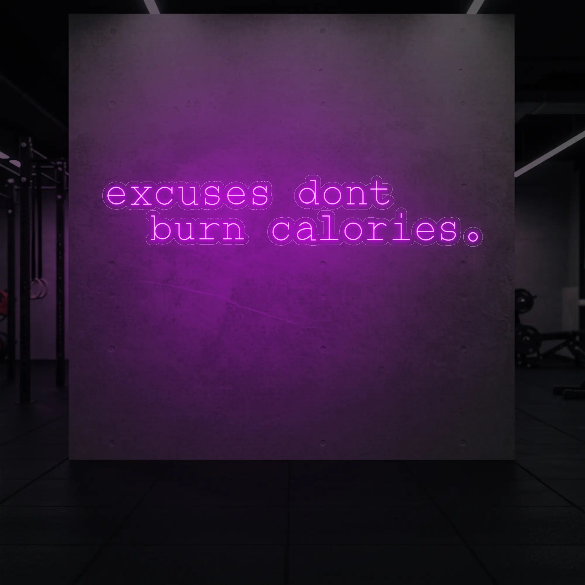 'Excuses Don’t Burn Calories' neon sign glowing in deep pink against a styled interior wall.