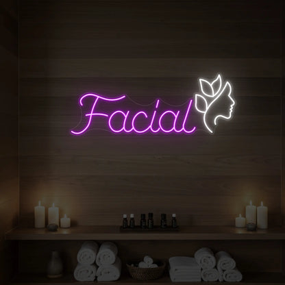 Photo of the 'Facial' neon sign with a botanical face silhouette glowing in deep pink against a styled interior wall.