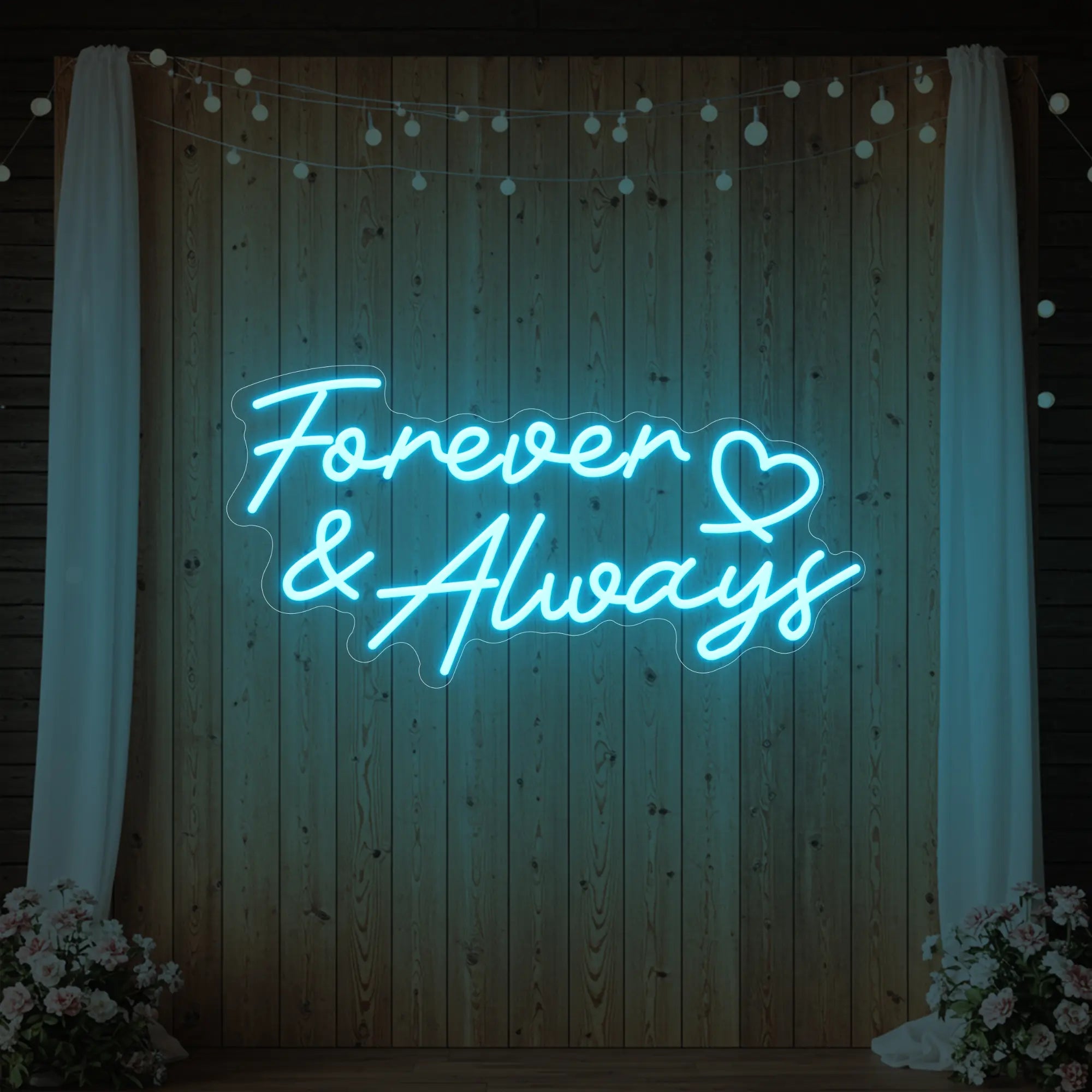 Photo of the 'Forever & Always' neon sign glowing in ice blue against a styled interior wall.