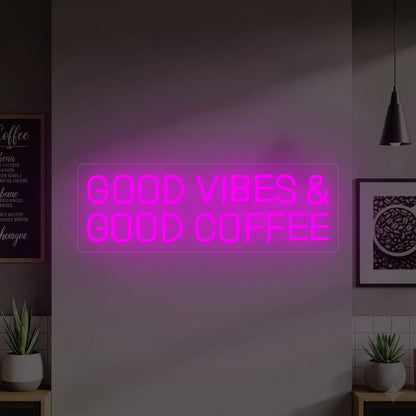 Photo of the 'GOOD VIBES & GOOD COFFEE' neon sign glowing in deep pink against a styled interior wall.