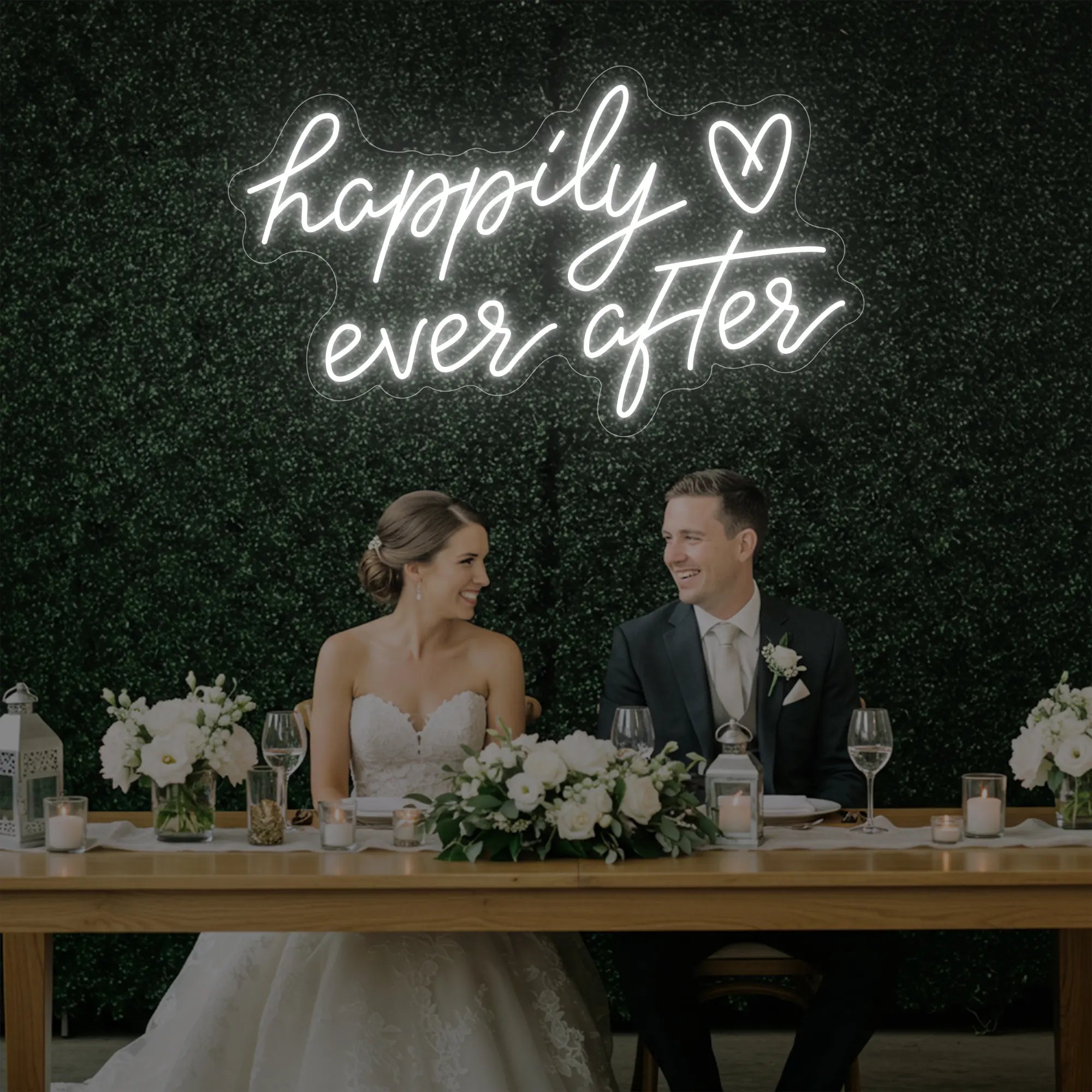Photo of the 'Happily Ever After' neon sign glowing in cool white against a styled interior wall.
