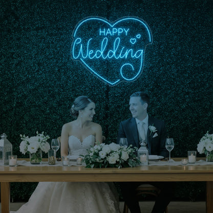 Photo of the 'Happy Wedding' neon sign glowing in ice blue against a styled interior wall.