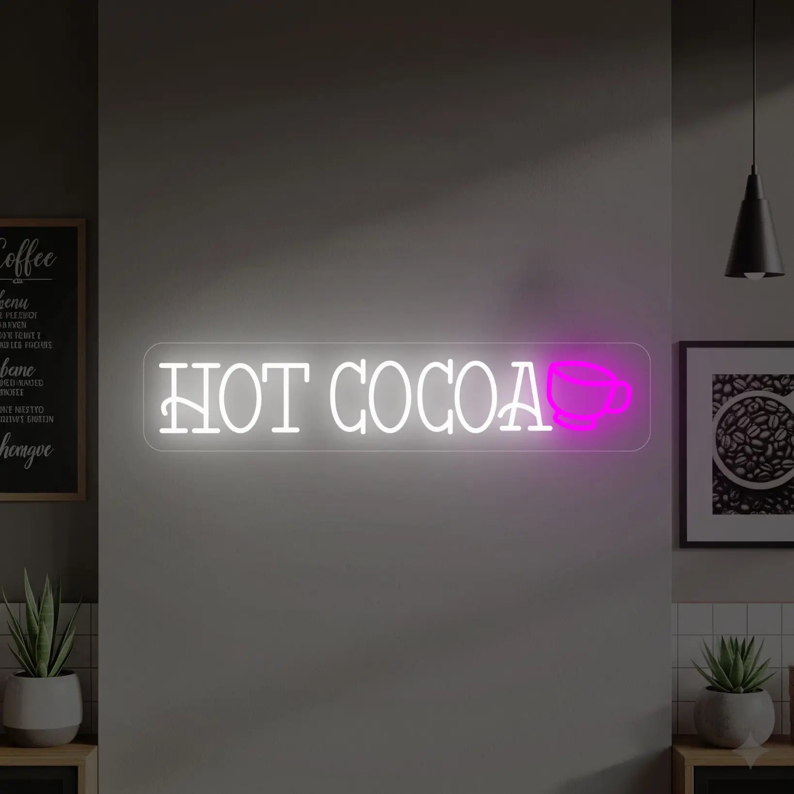 Photo of the 'HOT COCOA' neon sign glowing in cool white with a pink cup icon against a neutral interior wall.
