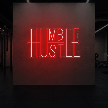  'Humble Hustle' neon sign glowing in red against a styled interior wall.
