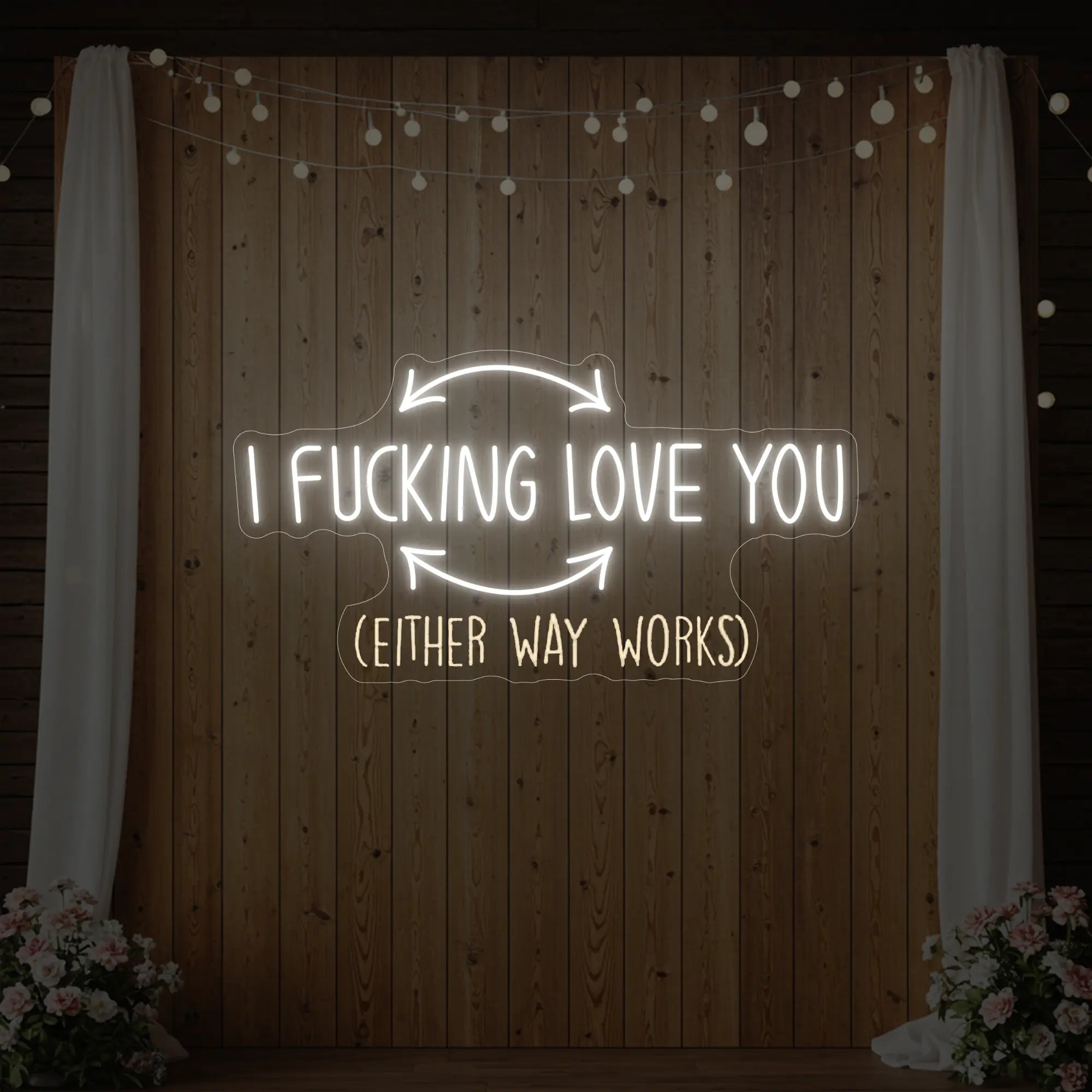 Photo of the 'I F'ing Love You' neon sign glowing in cool white against a styled interior wall.