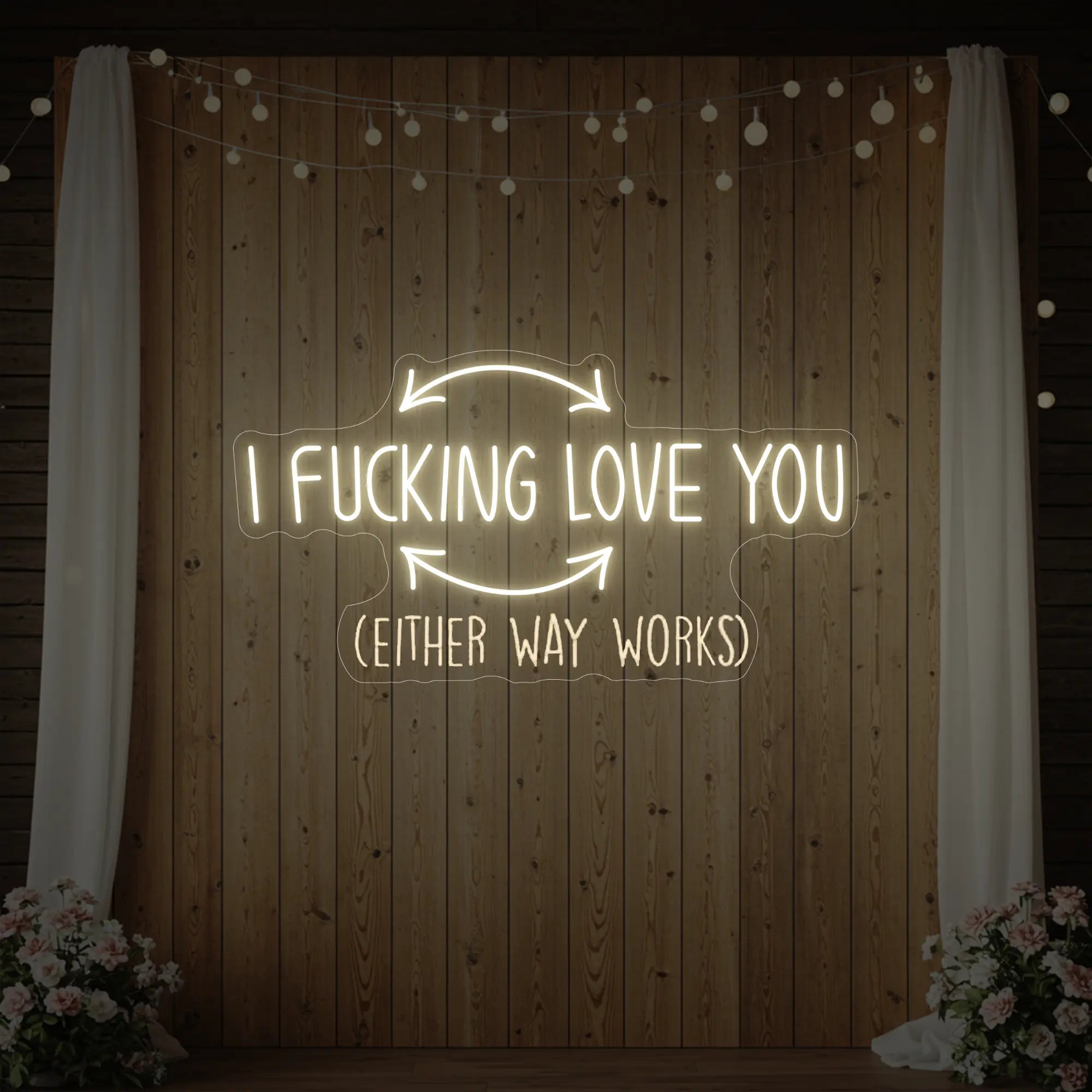 Photo of the 'I F'ing Love You' neon sign glowing in warm white against a styled interior wall.