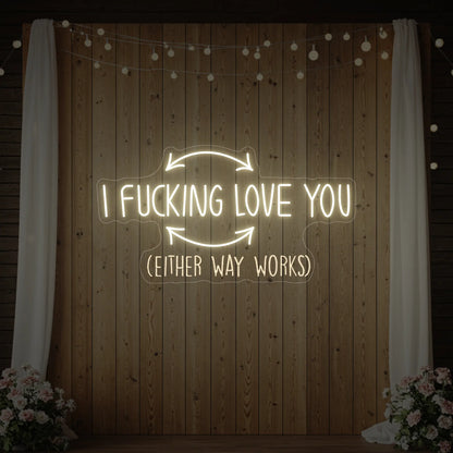 Photo of the 'I F'ing Love You' neon sign glowing in warm white against a styled interior wall.
