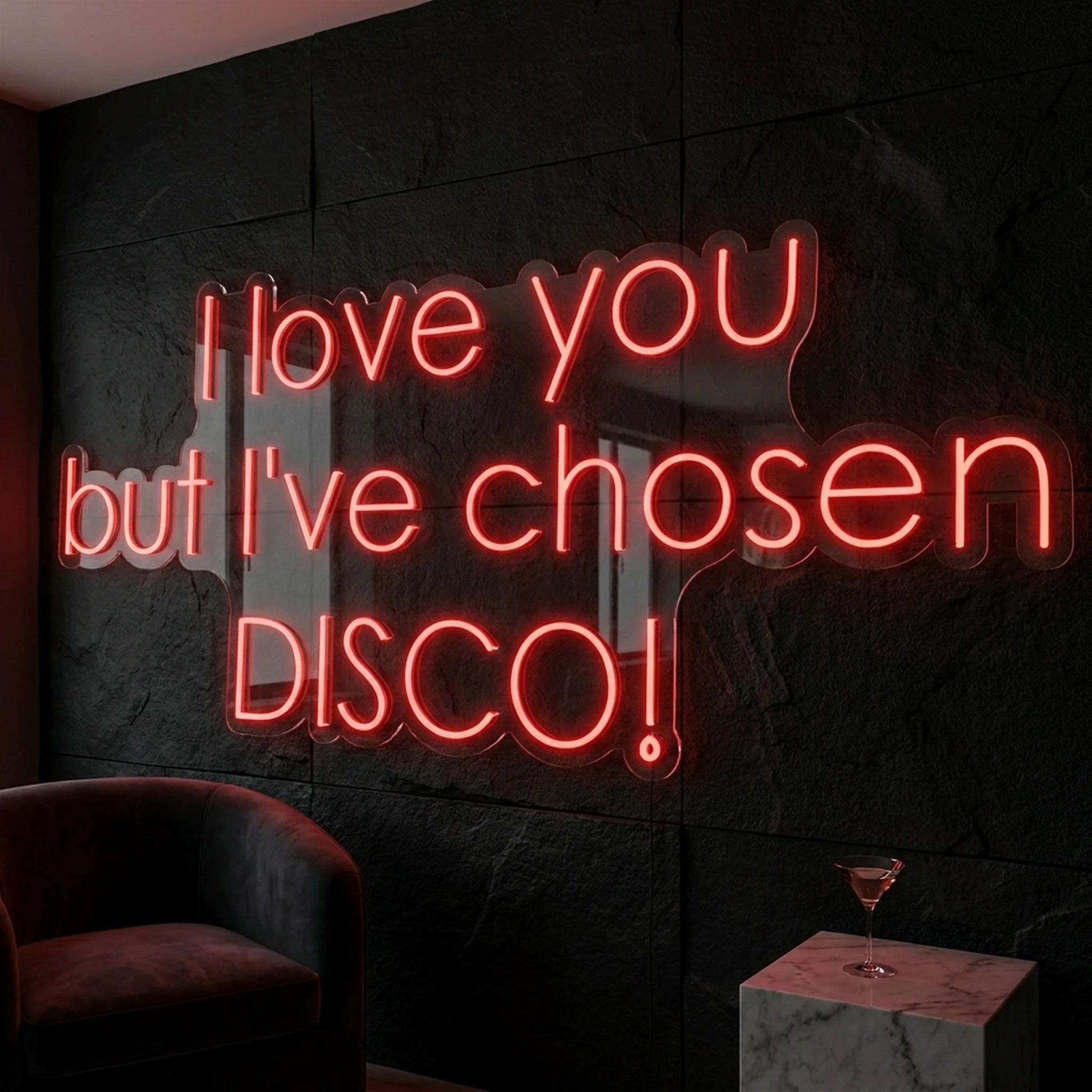 Photo of the 'I Love You But I’ve Chosen Disco' neon sign glowing in red against a styled interior wall.