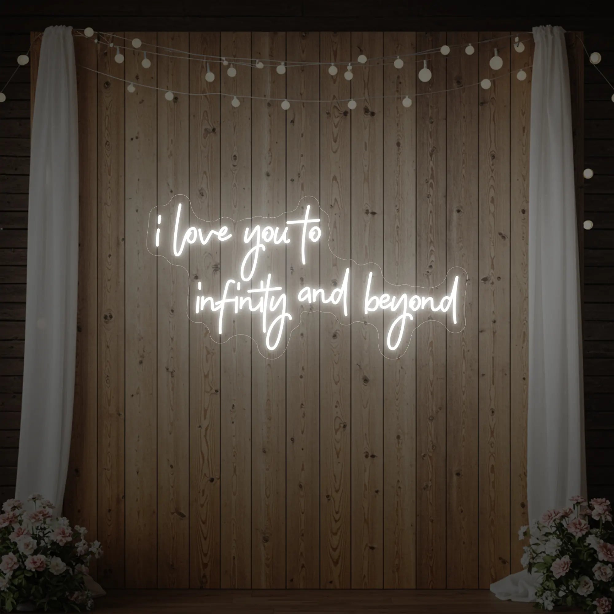 Photo of the 'I Love You to Infinity and Beyond' neon sign glowing in cool white against a styled interior wall.