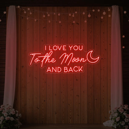 Photo of the 'I Love You To The Moon And Back' neon sign glowing in red against a styled interior wall.