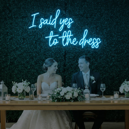 Photo of the 'I Said Yes To The Dress' neon sign glowing in ice blue against a styled interior wall.