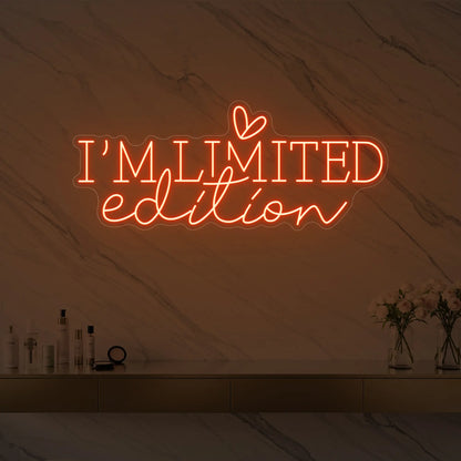 Photo of the 'I’M LIMITED edition' neon sign with a heart icon glowing in golden yellow against a styled interior wall.