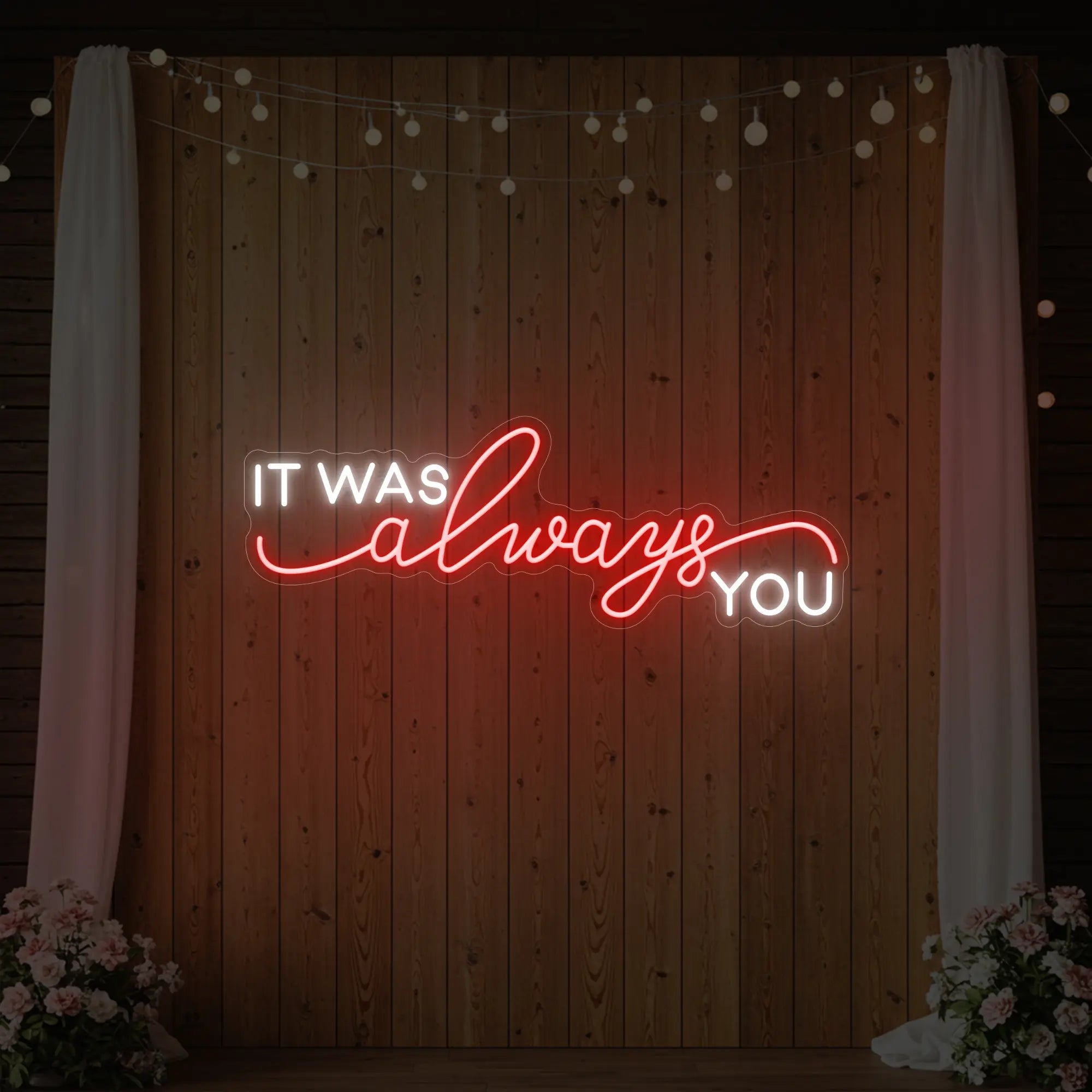 Photo of the 'It Was Always You' neon sign glowing in red against a styled interior wall.