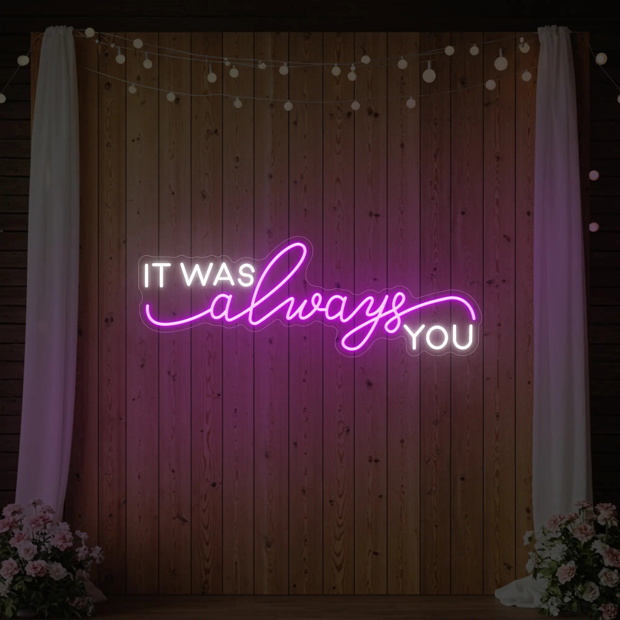 Photo of the 'It Was Always You' neon sign glowing in deep pink against a styled interior wall.