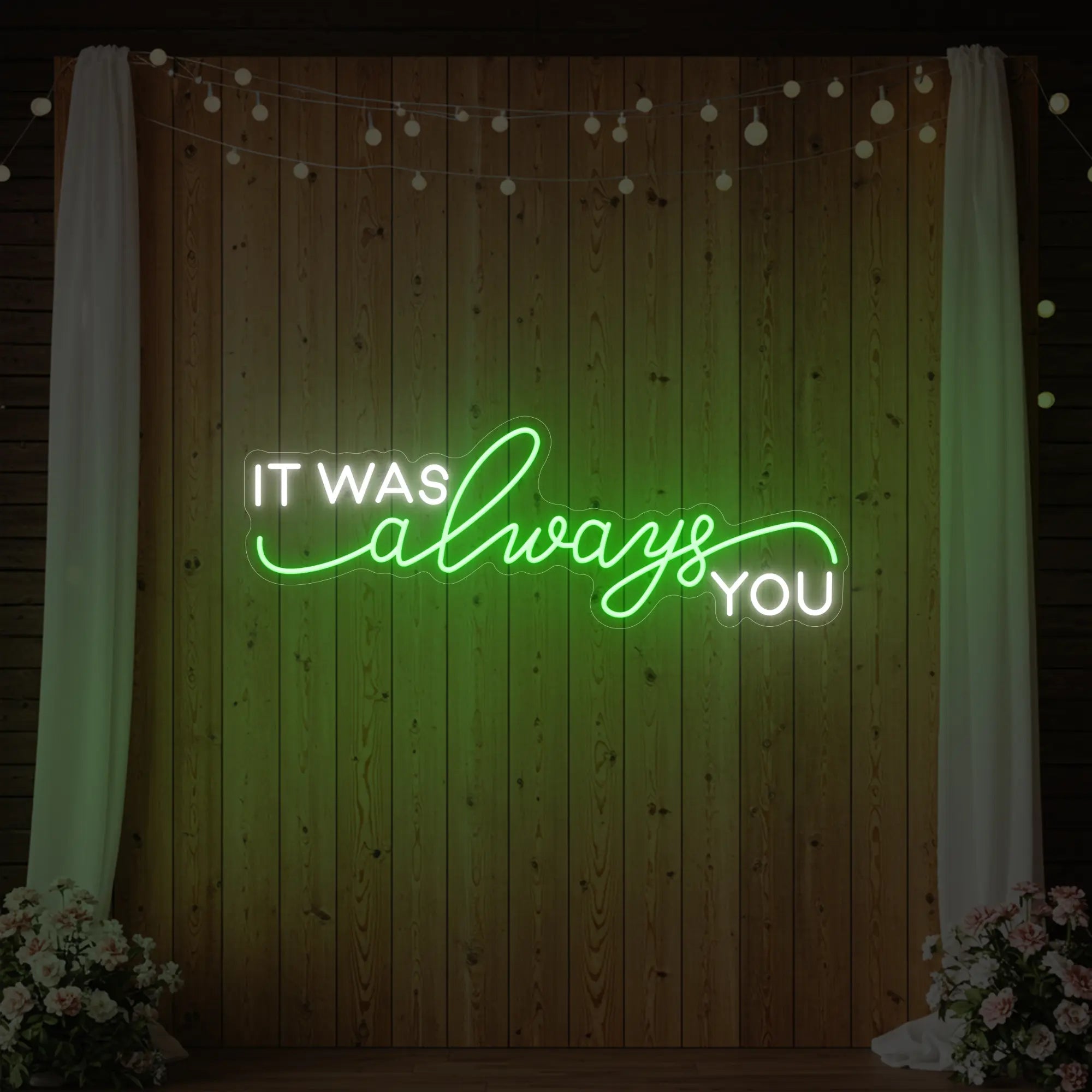 Photo of the 'It Was Always You' neon sign glowing in green against a styled interior wall.
