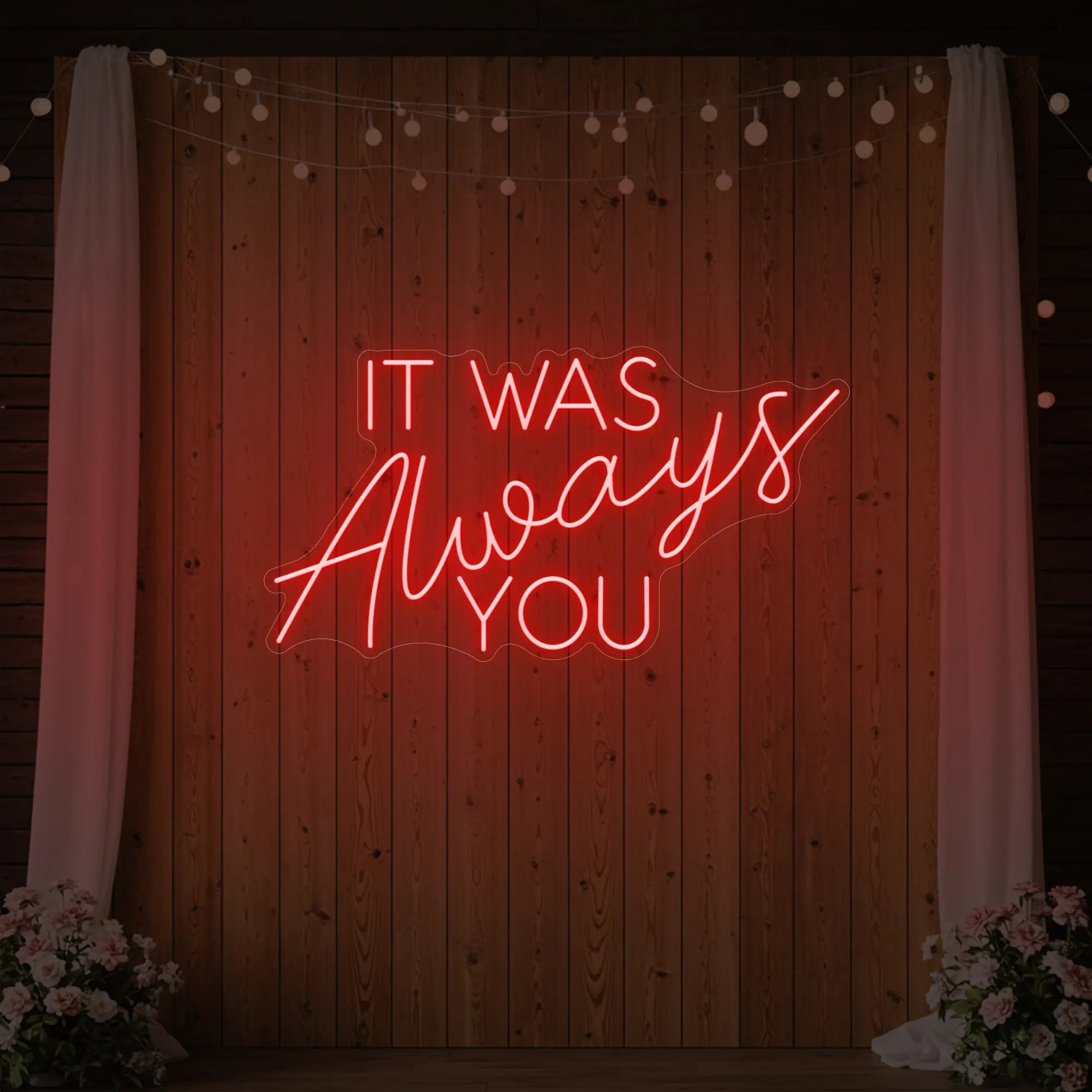 Photo of the 'It Was Always You' neon sign glowing in red against a styled interior wall.