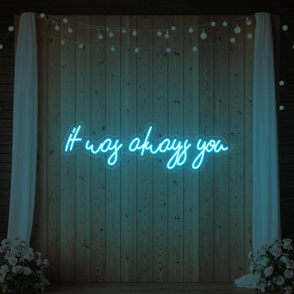 Photo of the 'It Was Always You' neon sign glowing in ice blue against a styled interior wall.
