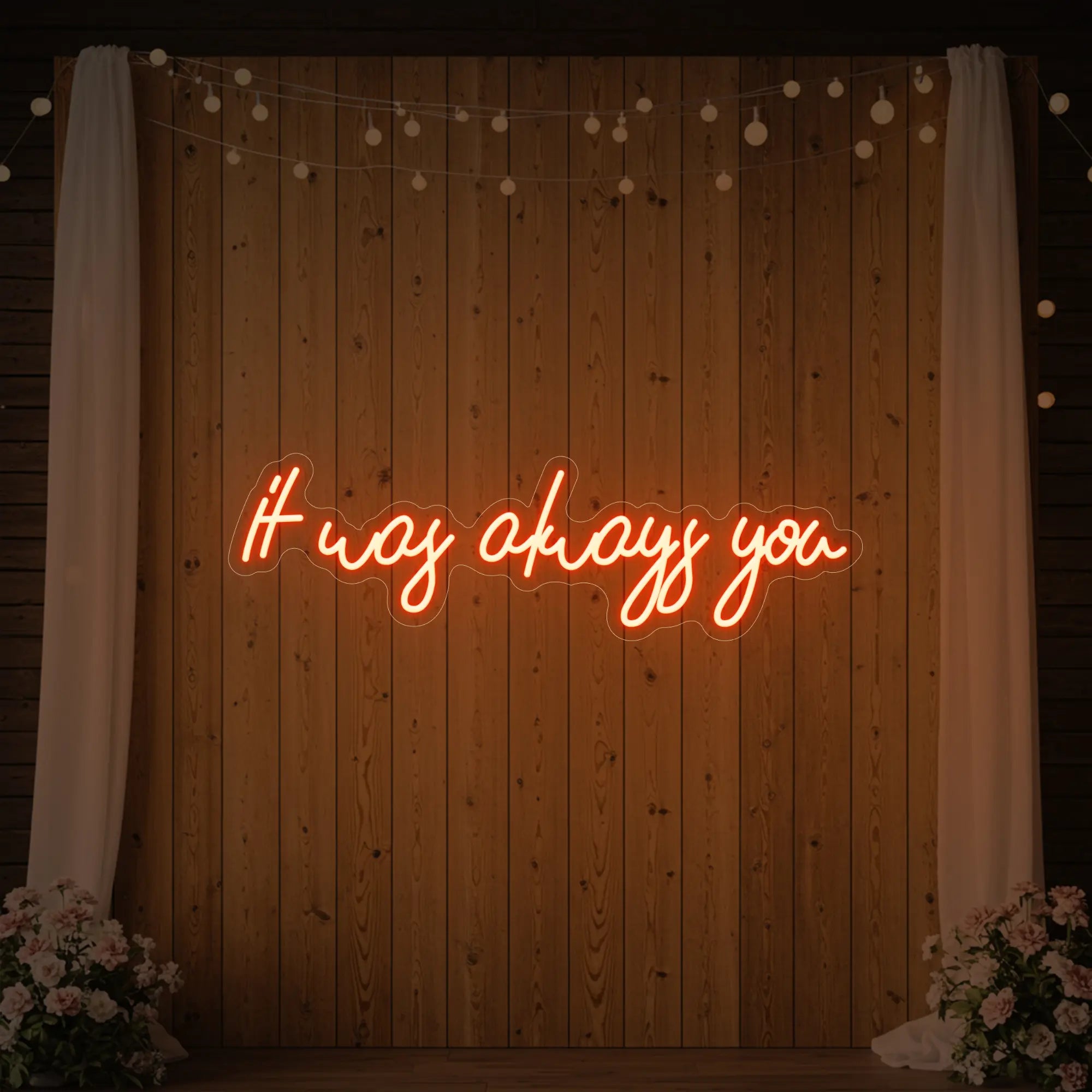 Photo of the 'It Was Always You' neon sign glowing in golden yellow against a styled interior wall.