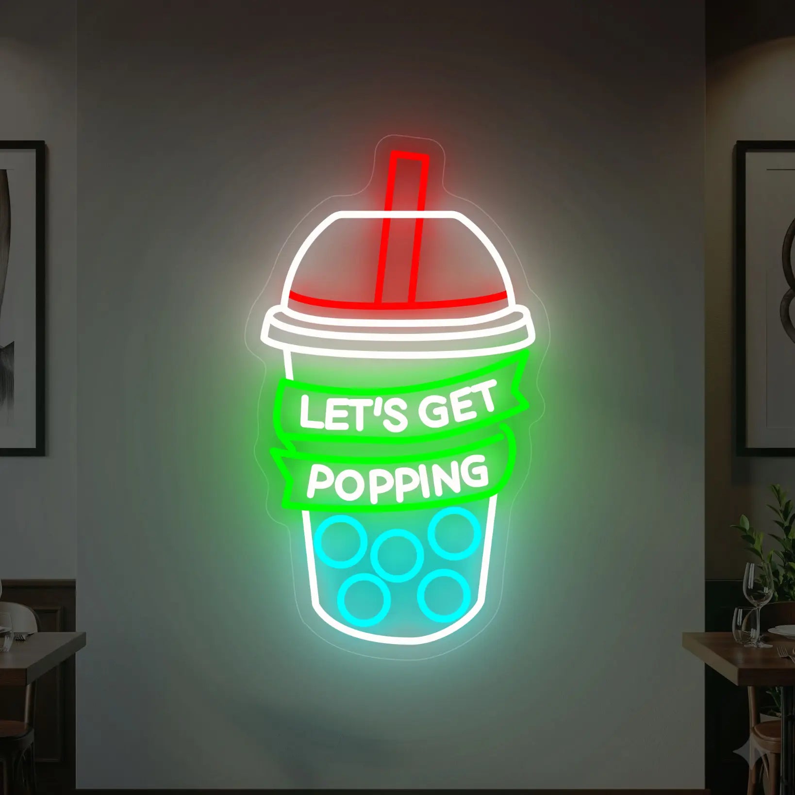 Photo of the 'LET’S GET POPPING' neon sign glowing in multi-color against a styled interior wall.