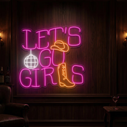 Photo of the 'Let's Go Girls' neon sign glowing in multi-color against a styled interior wall.