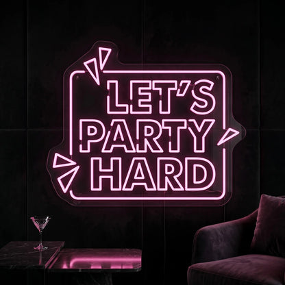 Photo of the 'Let's Party Hard' neon sign glowing in peach pink against a styled interior wall.