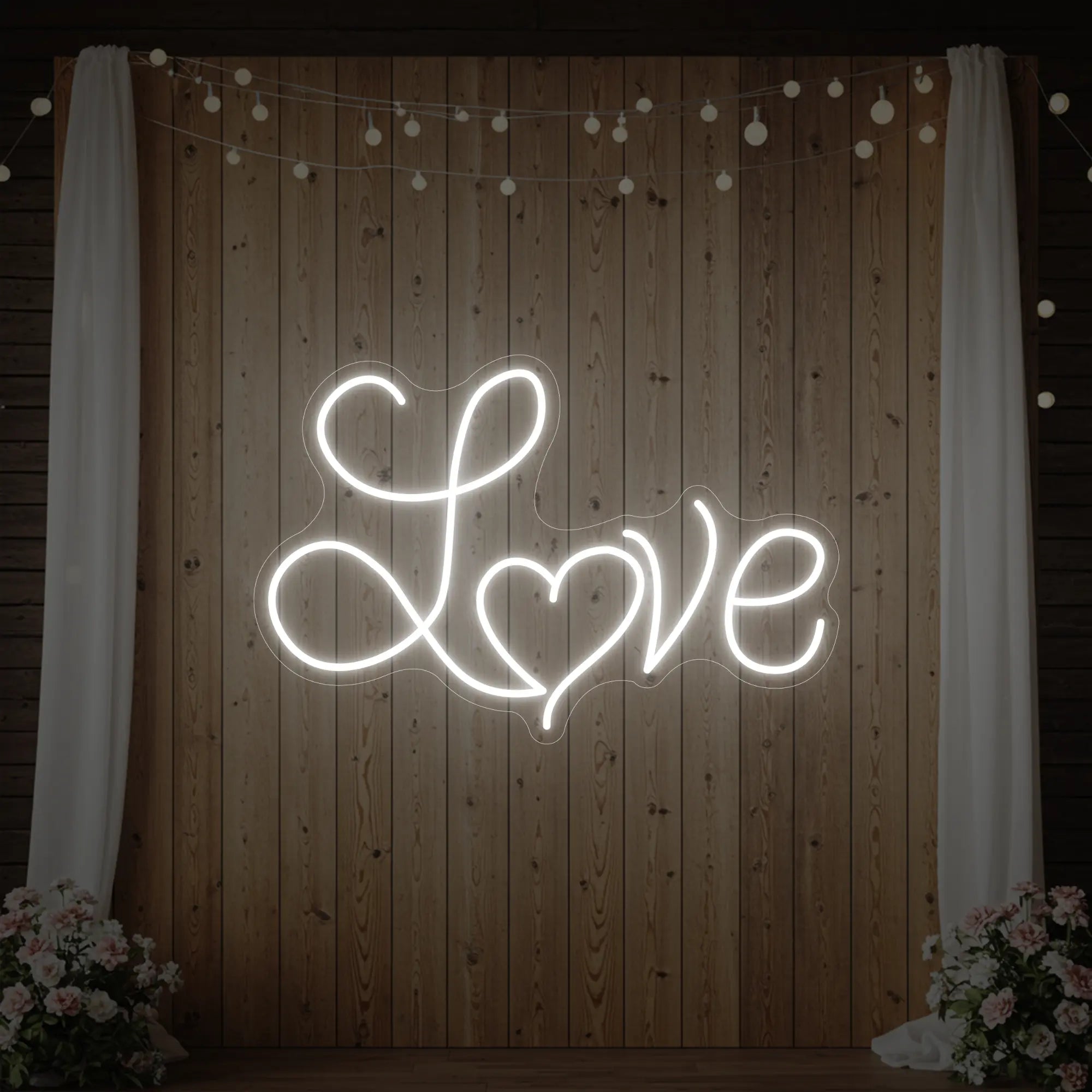 Photo of the 'Love Heart' neon sign glowing in cool white against a styled interior wall.