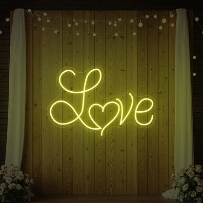 Photo of the 'Love Heart' neon sign glowing in lemon yellow against a styled interior wall.