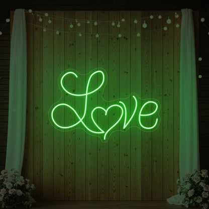 Photo of the 'Love Heart' neon sign glowing in green against a styled interior wall.