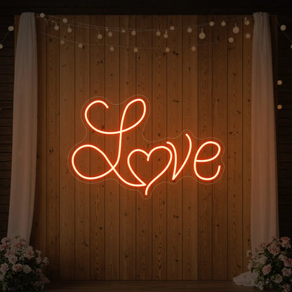 Photo of the 'Love Heart' neon sign glowing in golden yellow against a styled interior wall.
