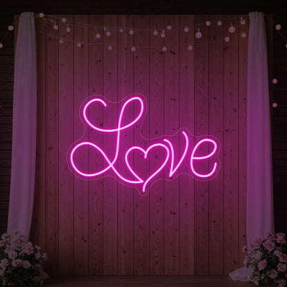 Photo of the 'Love Heart' neon sign glowing in light pink against a styled interior wall.