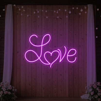 Photo of the 'Love Heart' neon sign glowing in deep pink against a styled interior wall.