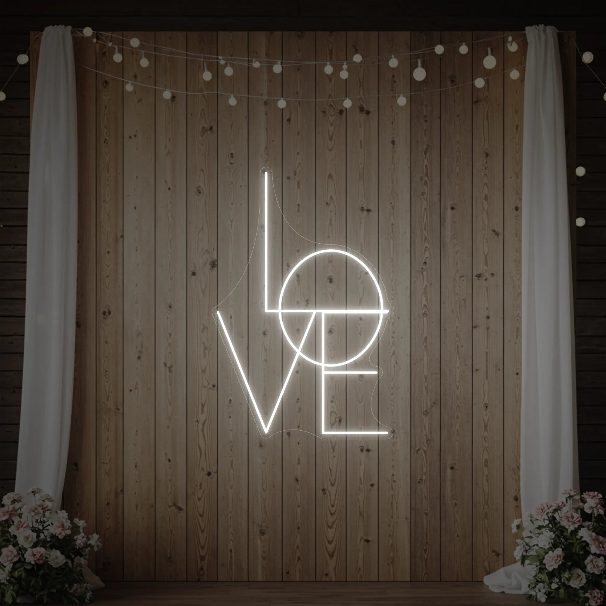 Photo of the 'LOVE' neon sign glowing in cool white against a styled interior wall.