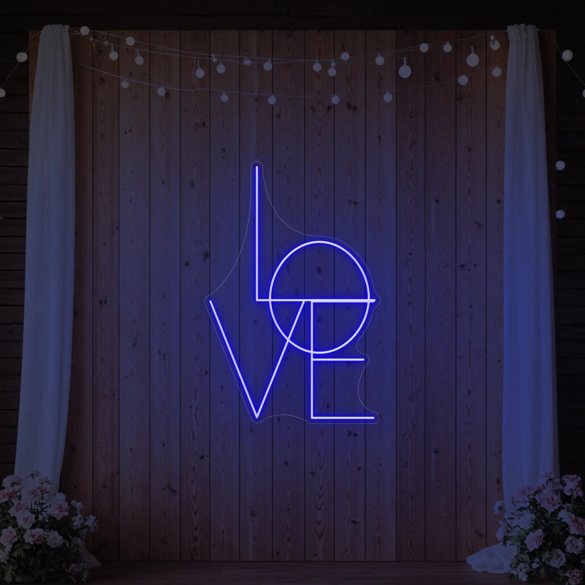 Photo of the 'LOVE' neon sign glowing in deep blue against a styled interior wall.