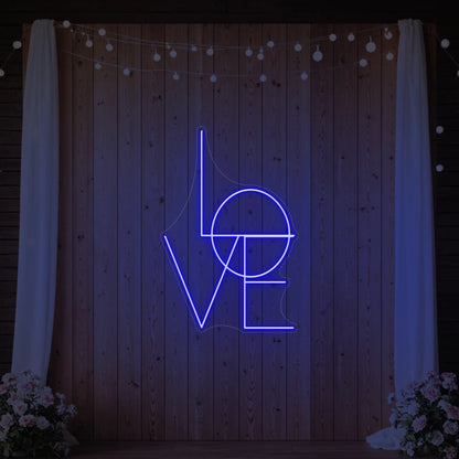 Photo of the 'LOVE' neon sign glowing in deep blue against a styled interior wall.