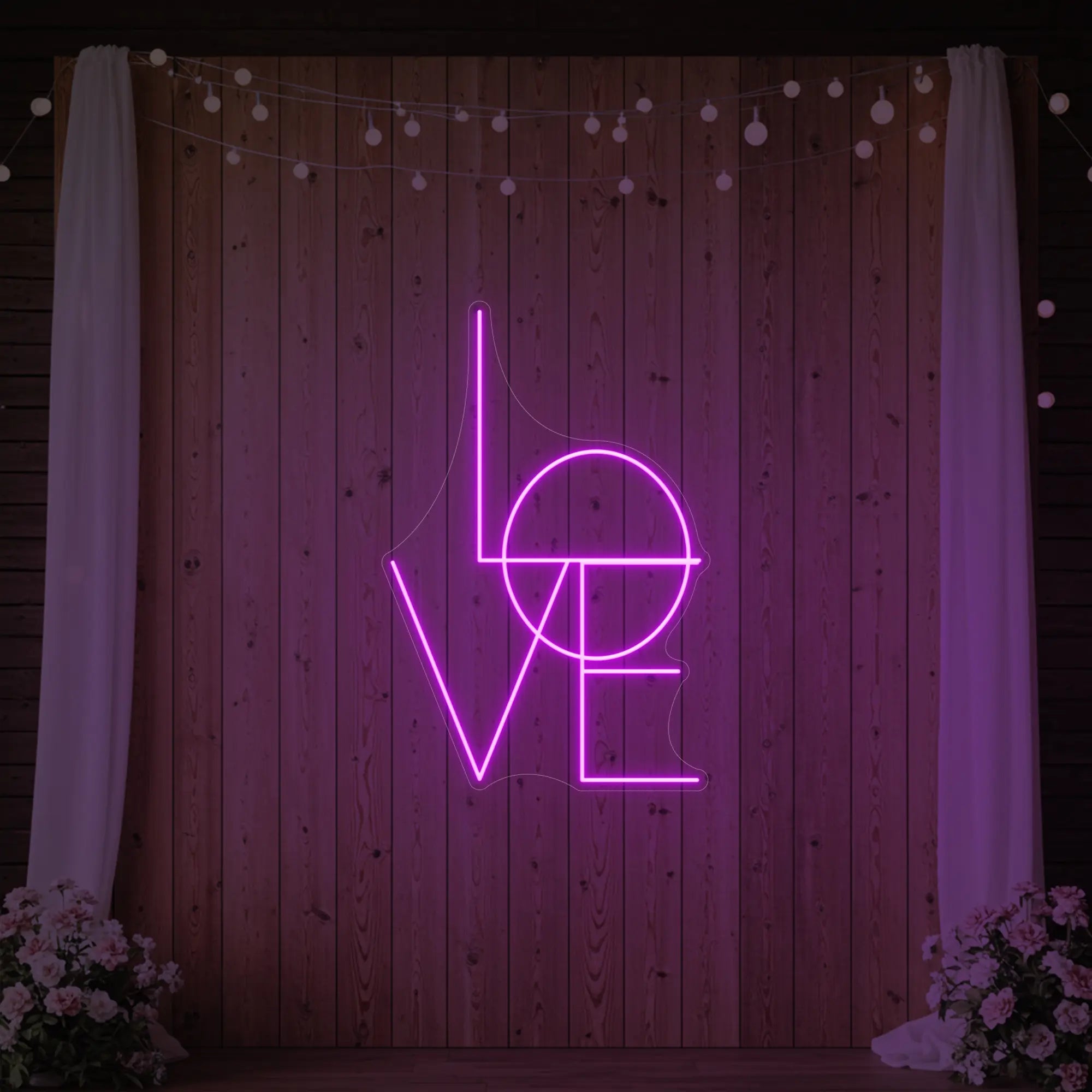 Photo of the 'LOVE' neon sign glowing in deep pink against a styled interior wall.